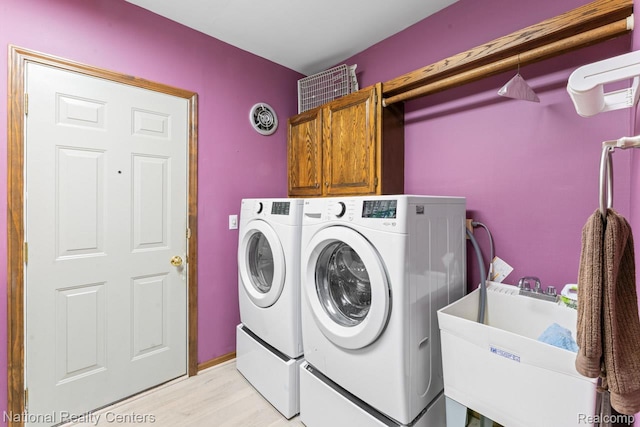 7500 Deerhill Dr, Clarkston, MI 48346 - washroom with washer and clothes dryer, cabinet space, and light wood finished floors