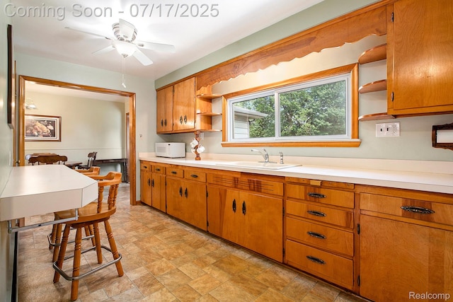 22950 Koths St, Taylor, MI 48180 - kitchen with open shelves, white microwave, light countertops, and brown cabinetry