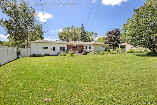 22950 Koths St, Taylor, MI 48180 - back of property featuring a fenced backyard, a wooden deck, and a chimney