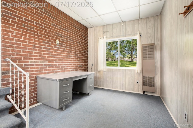 22950 Koths St, Taylor, MI 48180 - unfurnished office featuring a heating unit, a paneled ceiling, carpet flooring, brick wall, and wooden walls