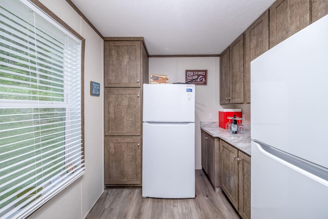 17648 Lost Lake Rd, Barryton, MI 49305 - kitchen with freestanding refrigerator, light wood-type flooring, and light countertops