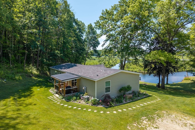 17648 Lost Lake Rd, Barryton, MI 49305 - view of side of property with roof with shingles, a yard, covered porch, and a water view