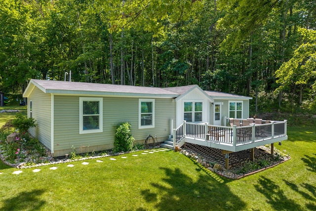 17648 Lost Lake Rd, Barryton, MI 49305 - back of property with a deck, a lawn, and a forest view