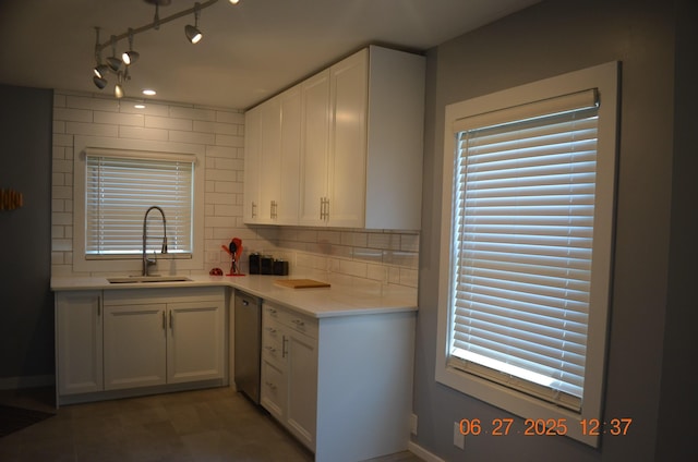 403 Hoover Ave, Benton Harbor, MI 49022 - kitchen featuring stainless steel dishwasher, white cabinets, tasteful backsplash, light countertops, and plenty of natural light