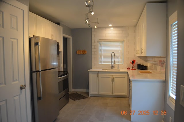 403 Hoover Ave, Benton Harbor, MI 49022 - kitchen featuring stainless steel appliances, backsplash, light countertops, white cabinetry, and light tile patterned floors