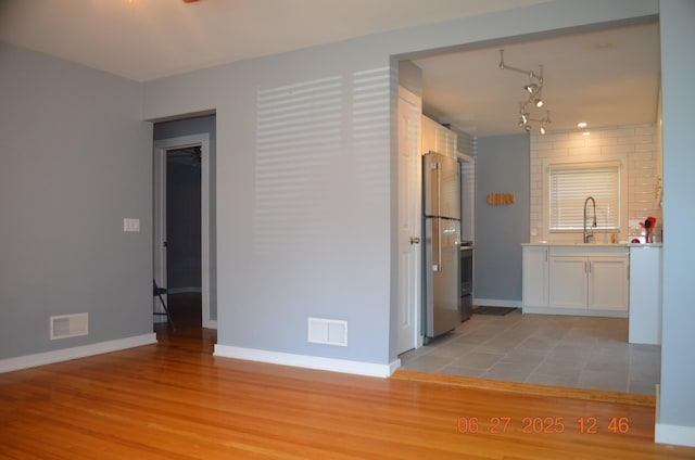 403 Hoover Ave, Benton Harbor, MI 49022 - kitchen featuring freestanding refrigerator, light wood finished floors, white cabinets, and light countertops
