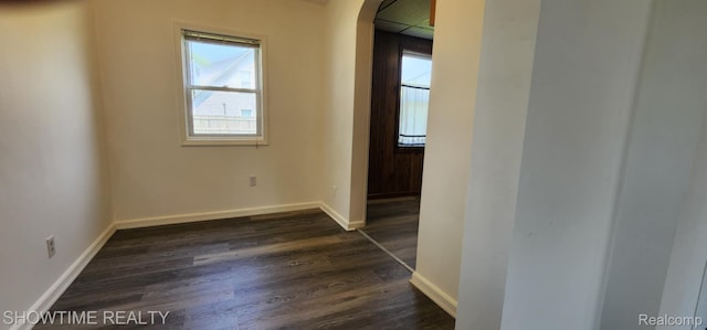 9825 Willow Ct, Clay, MI 48001 - empty room with arched walkways, plenty of natural light, and dark wood-style flooring