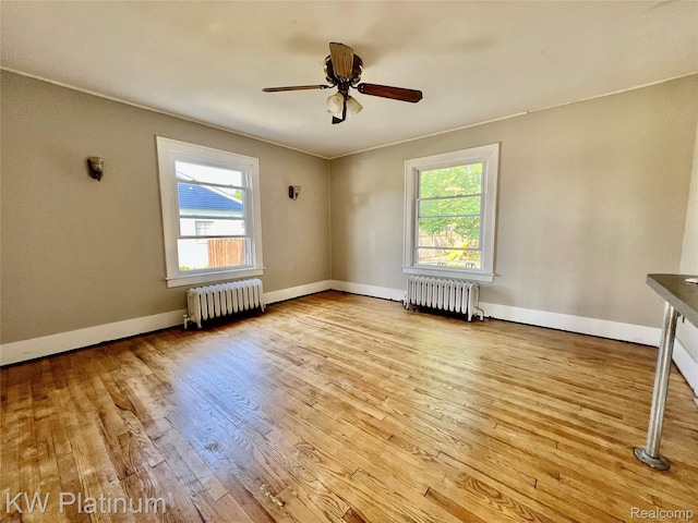 2109 Military St, Port Huron, MI 48060 - unfurnished room featuring radiator heating unit, plenty of natural light, and wood-type flooring