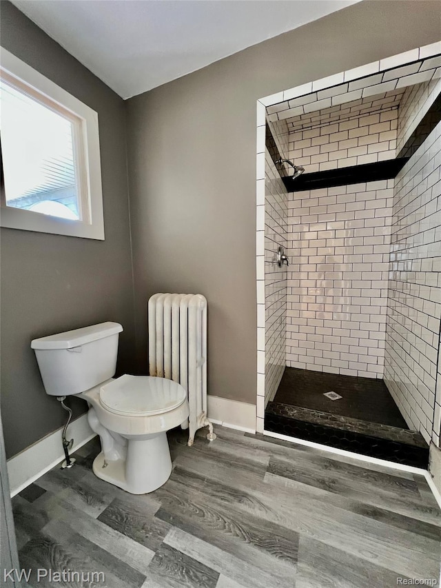 2109 Military St, Port Huron, MI 48060 - bathroom featuring radiator, a shower stall, and wood finished floors