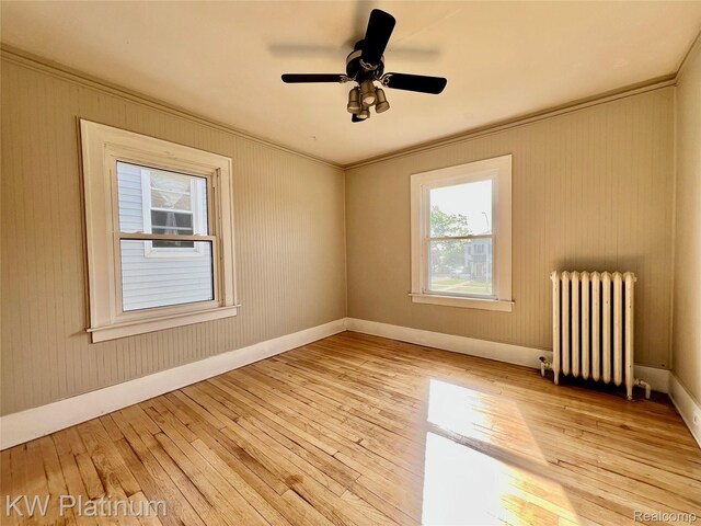 2109 Military St, Port Huron, MI 48060 - empty room with radiator heating unit, light wood-style floors, ornamental molding, and ceiling fan