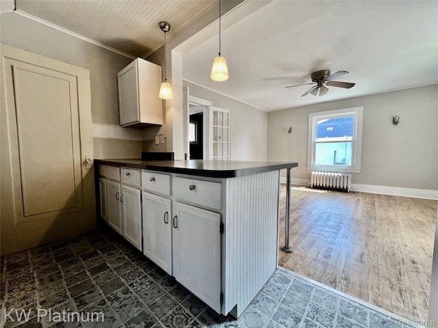 2109 Military St, Port Huron, MI 48060 - kitchen featuring radiator heating unit, a peninsula, dark countertops, ceiling fan, and white cabinets