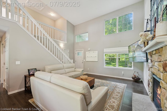 4577 Oaklawn Dr, Pinckney, MI 48169 - living room featuring stairway, a towering ceiling, plenty of natural light, a fireplace, and hardwood / wood-style flooring