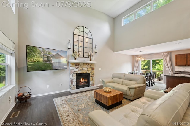 4577 Oaklawn Dr, Pinckney, MI 48169 - living room with a high ceiling, wood finished floors, a stone fireplace, and a chandelier