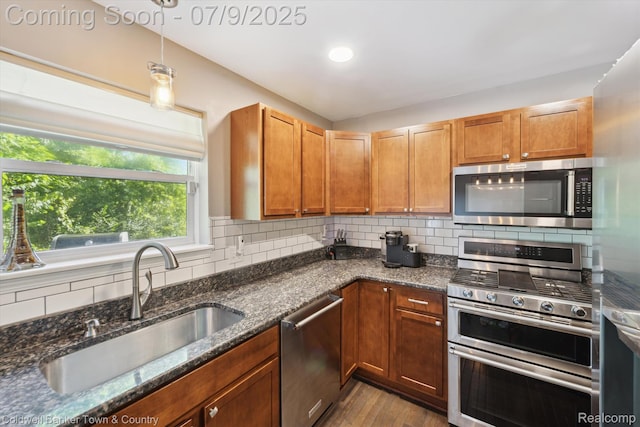 4577 Oaklawn Dr, Pinckney, MI 48169 - kitchen featuring stainless steel appliances, dark stone countertops, dark wood-style floors, and backsplash
