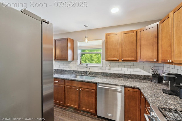 4577 Oaklawn Dr, Pinckney, MI 48169 - kitchen featuring appliances with stainless steel finishes, decorative backsplash, dark wood-type flooring, and pendant lighting