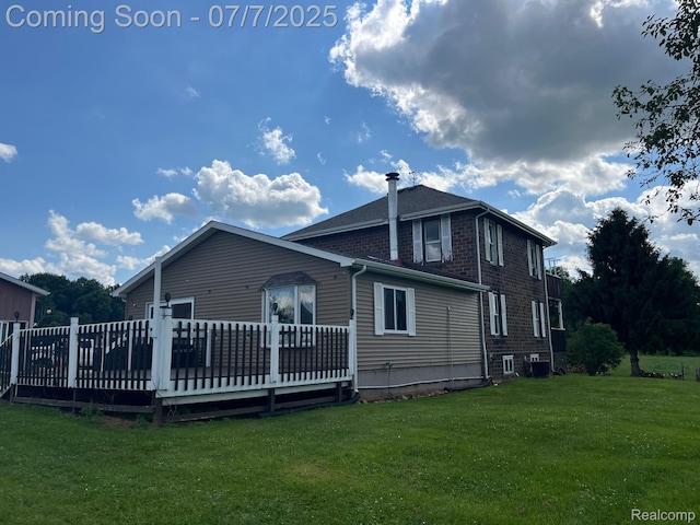 3500 Schlaud Rd, North Branch, MI 48461 - rear view of house with a yard, a wooden deck, and brick siding