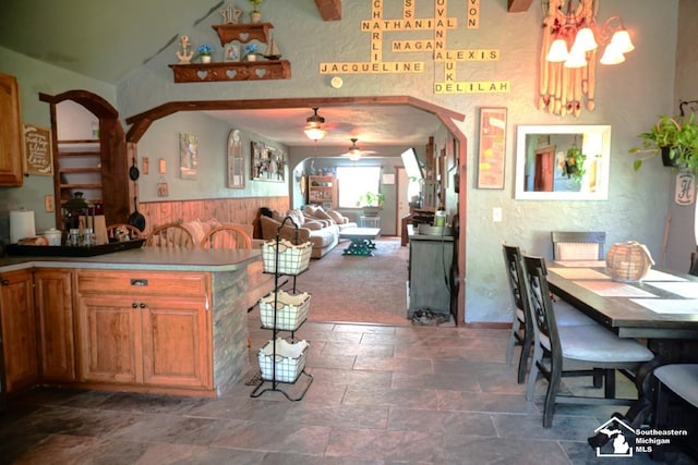 5985 Shady Ln, Newport, MI 48166 - kitchen featuring dark stone finish flooring, a ceiling fan, wainscoting, arched walkways, and a chandelier