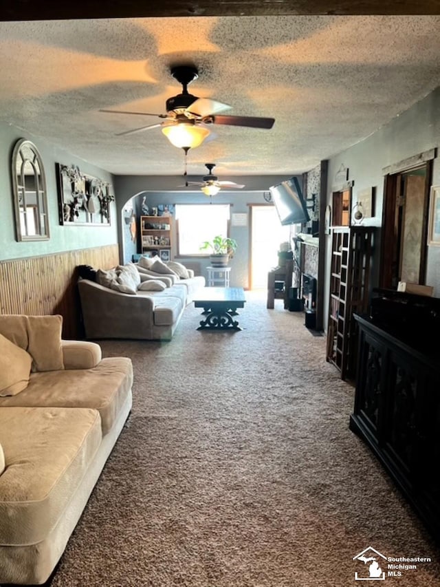5985 Shady Ln, Newport, MI 48166 - living room featuring a wainscoted wall, a ceiling fan, carpet flooring, a textured ceiling, and wood walls