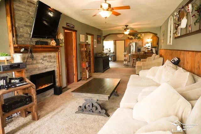 5985 Shady Ln, Newport, MI 48166 - living area featuring a ceiling fan, a wainscoted wall, arched walkways, wooden walls, and carpet flooring