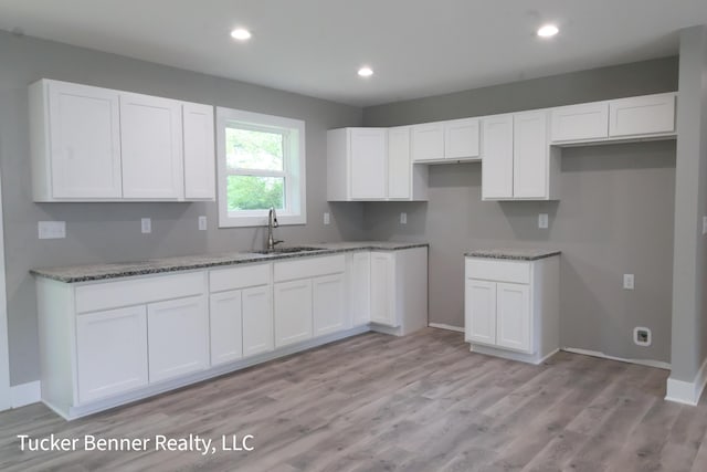 518 S Sullivan Ave, Fremont, MI 49412 - kitchen with white cabinetry, light stone counters, light wood-style floors, and recessed lighting