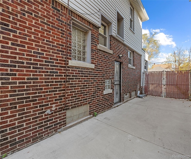 16554 Muirland St, Detroit, MI 48221 - view of property exterior featuring a gate, a patio area, and brick siding