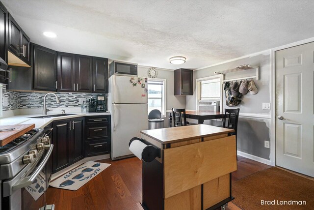 11982 Erica Ln Unit 39, Shelbyville, MI 49344 - kitchen featuring freestanding refrigerator, stainless steel gas range, dark wood-type flooring, tasteful backsplash, and a textured ceiling