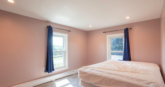 6550 Black River Rd, Croswell, MI 48422 - carpeted bedroom featuring a baseboard heating unit, multiple windows, and recessed lighting