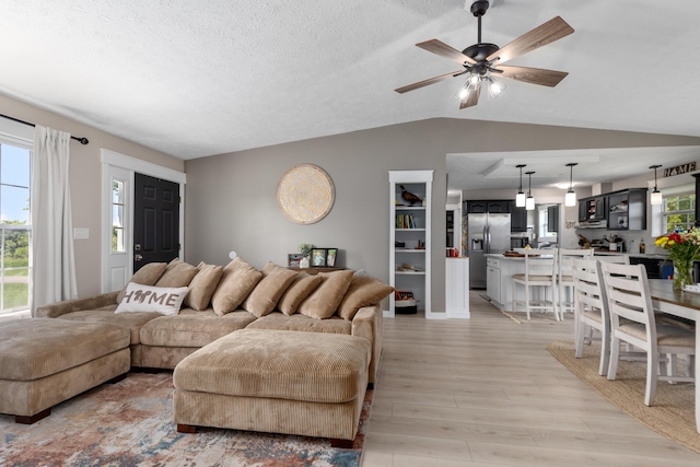 7241 Cherry Ave, Kewadin, MI 49648 - living area with vaulted ceiling, light wood-style floors, and a ceiling fan