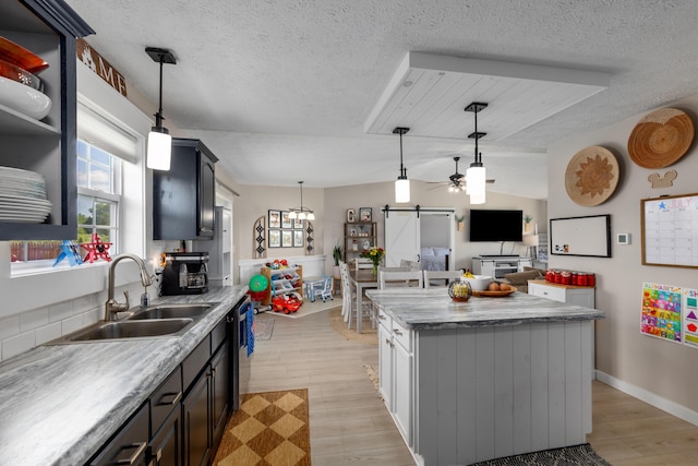 7241 Cherry Ave, Kewadin, MI 49648 - kitchen with a barn door, a textured ceiling, light wood finished floors, ceiling fan, and plenty of natural light