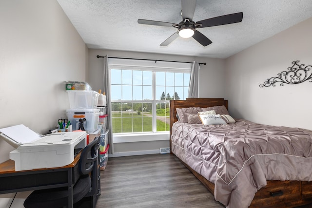 7241 Cherry Ave, Kewadin, MI 49648 - bedroom featuring wood finished floors, a textured ceiling, and a ceiling fan