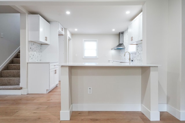 20157 Huntington Ave, Harper Woods, MI 48225 - kitchen with wall chimney exhaust hood, a peninsula, tasteful backsplash, white cabinets, and recessed lighting