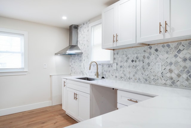 20157 Huntington Ave, Harper Woods, MI 48225 - kitchen featuring wall chimney exhaust hood, decorative backsplash, light wood-style flooring, and light countertops