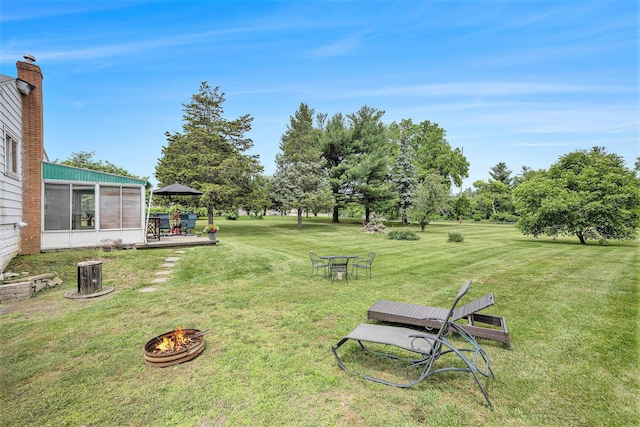 3477 Esson Dr, Grand Blanc, MI 48439 - view of grassy yard featuring a fire pit and a sunroom