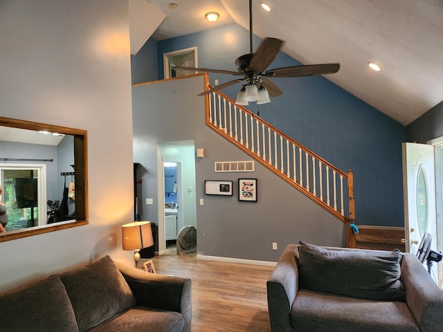 23967 Derek Dr, Sand Lake, MI 49343 - living room featuring ceiling fan, high vaulted ceiling, stairs, and wood finished floors