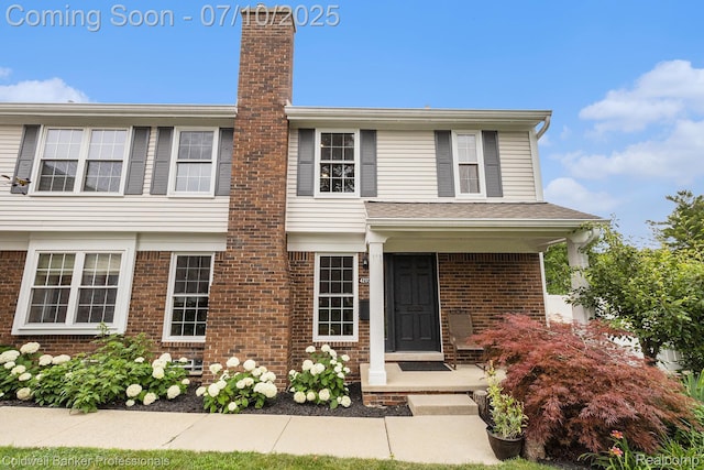 42173 Pellston Dr, Northville, MI 48167 - view of front facade with brick siding and a chimney