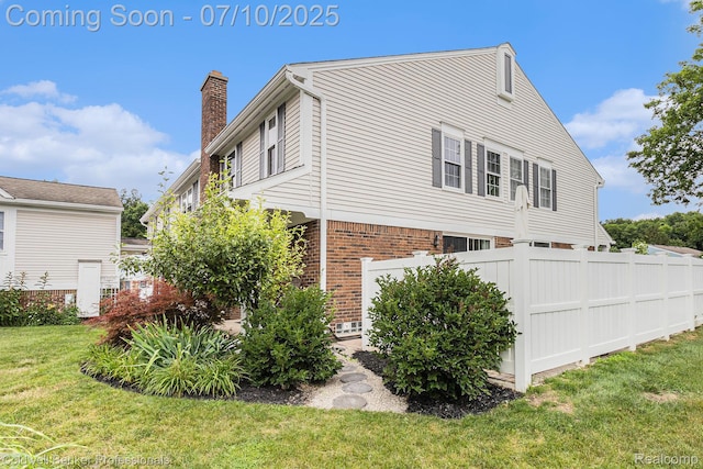 42173 Pellston Dr, Northville, MI 48167 - view of side of home featuring brick siding and a chimney