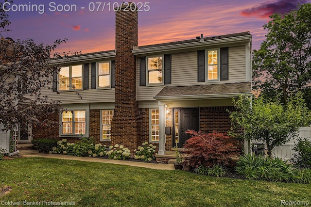 42173 Pellston Dr, Northville, MI 48167 - view of front of home with a yard, a chimney, and brick siding
