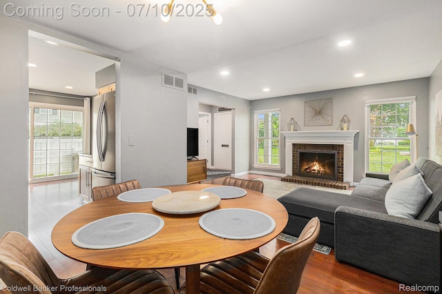 42173 Pellston Dr, Northville, MI 48167 - dining area with a brick fireplace, wood finished floors, and recessed lighting