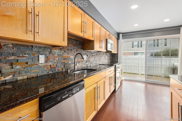 42173 Pellston Dr, Northville, MI 48167 - kitchen featuring appliances with stainless steel finishes, decorative backsplash, dark stone countertops, dark wood-type flooring, and recessed lighting
