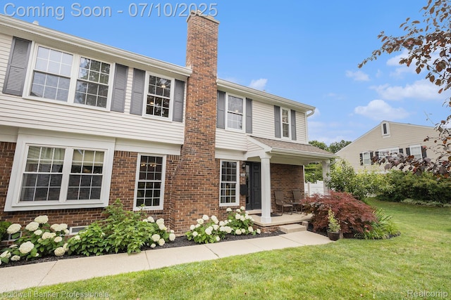 42173 Pellston Dr, Northville, MI 48167 - view of front of home featuring a chimney, a front yard, and brick siding