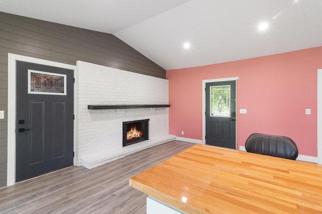 6750 Walters Rd, Clarkston, MI 48346 - living area featuring vaulted ceiling, wood finished floors, a brick fireplace, recessed lighting, and wooden walls