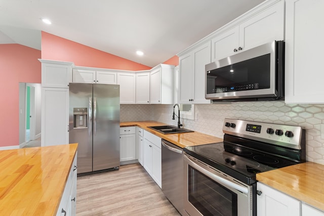 6750 Walters Rd, Clarkston, MI 48346 - kitchen with wood counters, stainless steel appliances, lofted ceiling, and white cabinetry