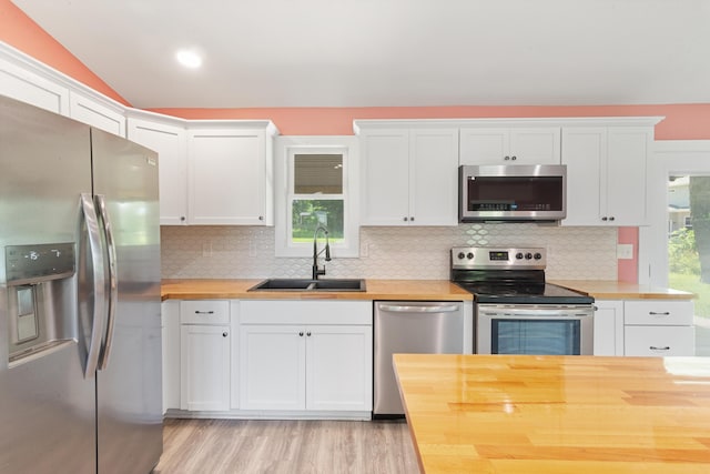 6750 Walters Rd, Clarkston, MI 48346 - kitchen with appliances with stainless steel finishes, butcher block countertops, white cabinets, backsplash, and vaulted ceiling