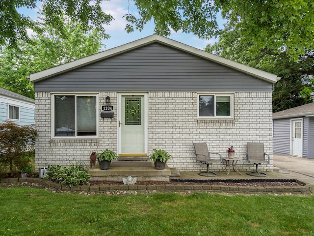 1204 S Campbell Rd, Royal Oak, MI 48067 - view of front of house featuring brick siding, a patio, and a front yard