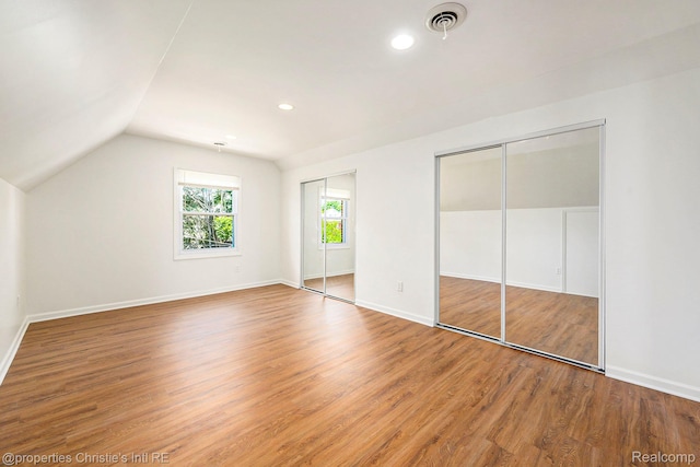 18661 Stoepel St, Detroit, MI 48221 - unfurnished bedroom with two closets, wood finished floors, vaulted ceiling, and recessed lighting