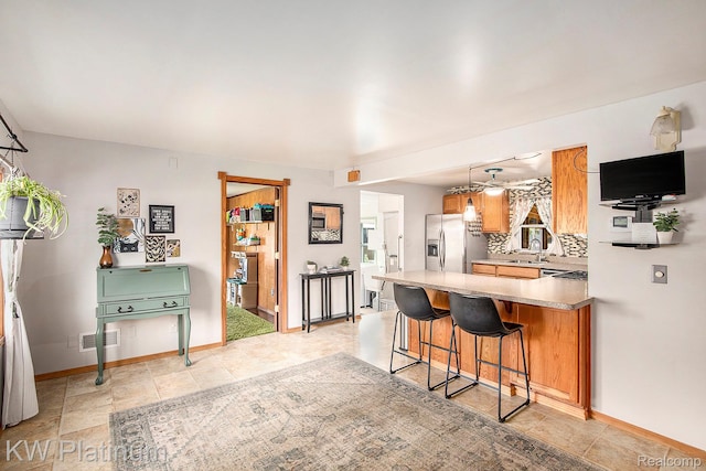 1509 Allen Rd, Kimball, MI 48074 - kitchen with stainless steel fridge, a peninsula, a breakfast bar, light countertops, and backsplash