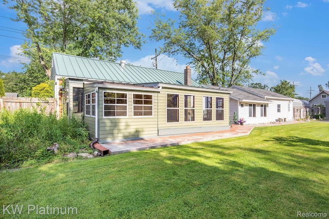 1509 Allen Rd, Kimball, MI 48074 - rear view of property featuring a chimney, a patio area, and a metal roof