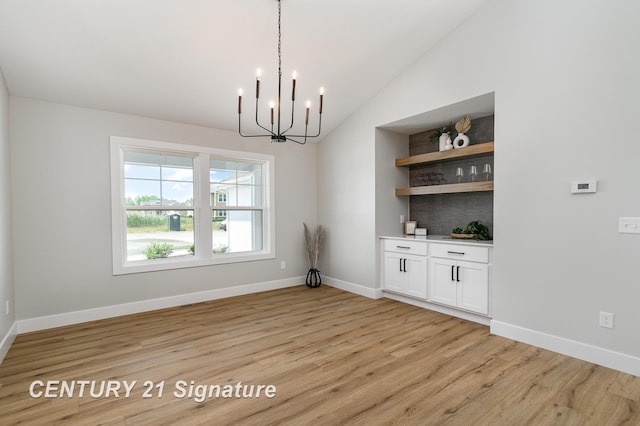 10464 Laurel Woods Pl, Freeland, MI 48623 - unfurnished dining area with a chandelier, vaulted ceiling, and light wood-style flooring