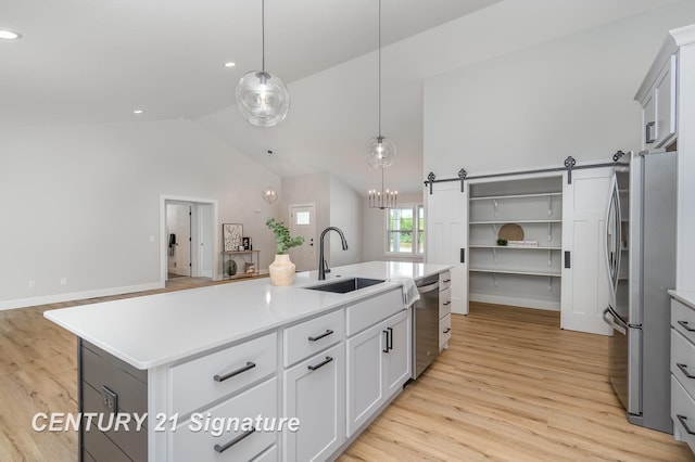 10464 Laurel Woods Pl, Freeland, MI 48623 - kitchen featuring stainless steel appliances, light wood-type flooring, light countertops, a kitchen island with sink, and recessed lighting