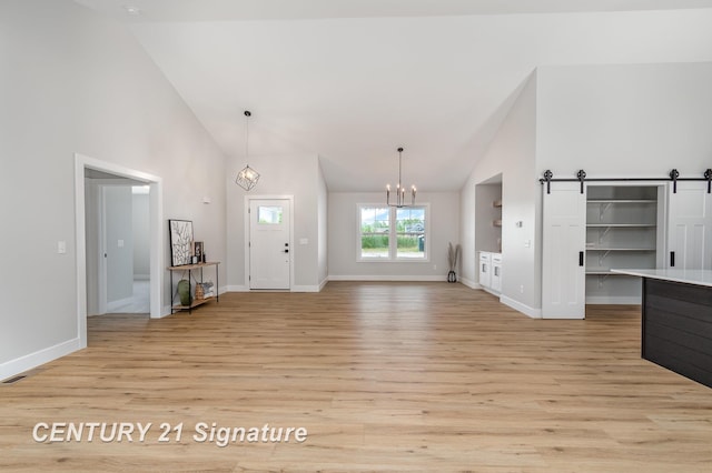 10464 Laurel Woods Pl, Freeland, MI 48623 - foyer entrance featuring light wood-style floors, a chandelier, high vaulted ceiling, and a barn door